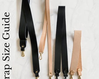 May include: Strap Size Guide featuring four leather straps with metal hardware. Includes a black Wide Adjustable Strap 28-50 x 1.5 inches, a tan Adjustable Strap 28-50 x 0.75 inches, a black Long Wide Strap 38 x 1.5 inches, and a tan Short Wide Strap 23.5 x 1.5 inches.