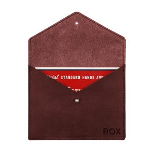 May include: A dark maroon suede envelope-style pouch with a pointed flap and a silver snap closure. The word ROX is embossed in the bottom right corner. Inside, a red card is visible with white text reading STANDARD HANDS AND.