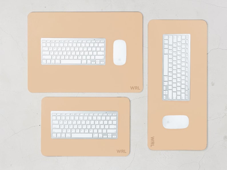 May include: Three beige desk mats with white keyboards and mice. The mats are rectangular and have rounded corners. The top mat has a keyboard and mouse. The bottom mat has a keyboard. The right mat has a keyboard and mouse. The mats have the text "WRL".