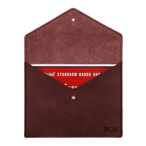 May include: A dark maroon suede envelope-style pouch with a pointed flap and a single silver snap closure. The word ROX is embossed in the bottom right corner. Inside, a red card displays the text: Official STANDARD HANDS AND.