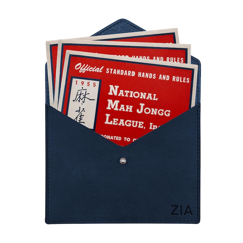 May include: A dark blue envelope-style case with a snap closure and the text ZIA embossed in the corner. Inside are several red cards with white text reading Official Standard Hands and Rules National Mah Jongg League, Inc. 1955.
