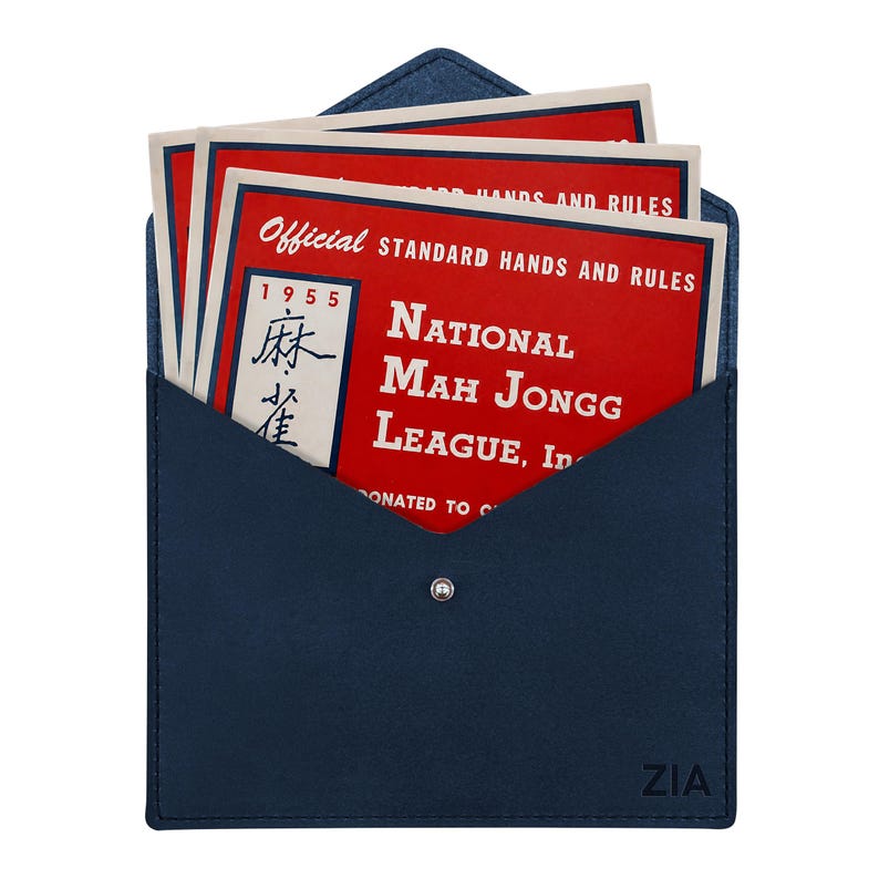 May include: A dark blue envelope-style case with a silver snap closure and the text ZIA embossed in the corner. Inside are red cards with white text reading Official Standard Hands and Rules National Mah Jongg League, Inc. 1955.