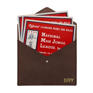 May include: A dark brown envelope-style case with a snap closure and the letters BRY embossed in gold. Inside are several red and white cards titled Official Standard Hands and Rules National Mah Jongg League, Inc. 1955.