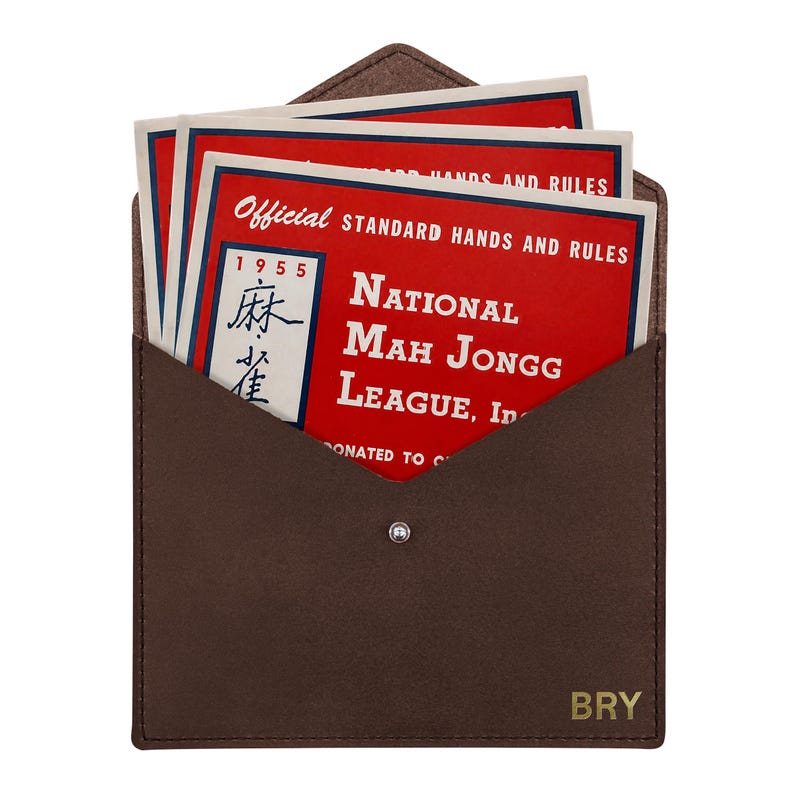 May include: A brown leather envelope-style case with a snap closure and the letters BRY embossed in the corner. Inside are several red and white cards titled Official Standard Hands and Rules National Mah Jongg League, Inc. 1955.