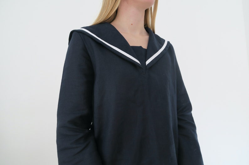 May include: A navy blue long-sleeved shirt with a white sailor collar.