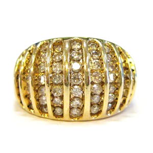 May include: A gold ring with a band of small round diamonds set in a dome shape.