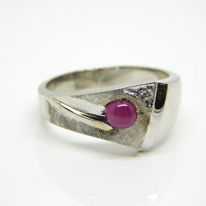 May include: A silver ring with a pink gemstone and a small diamond accent.