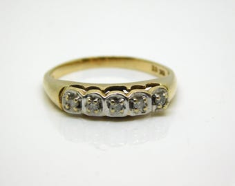 May include: A gold band ring with five small diamonds set in a row.