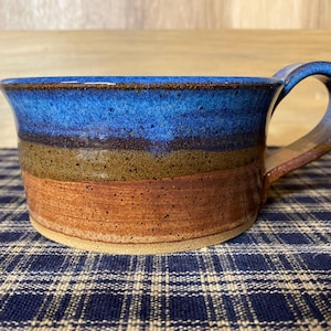 Light rust and floating blue pottery soup mug