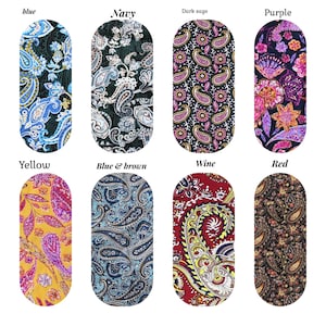 Op de afbeelding: Acht stofstalen met paisley-patronen in verschillende kleuren, waaronder blauw, marine, donkergroen, paars, geel, blauw en bruin, wijn en rood.
