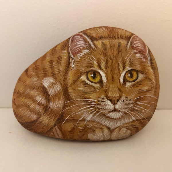 Arte rupestre pintado a mano: Gato atigrado naranja sobre roca marina