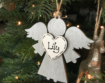 May include: A silver wooden angel Christmas ornament with a heart-shaped tag that says "Lily".