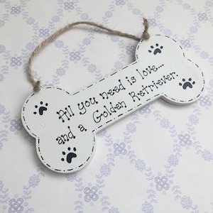 Peut inclure: Pancarte en bois blanc en forme d'os avec des empreintes de pattes noires et le texte "Tout ce dont vous avez besoin, c'est de l'amour... et d'un Golden Retriever."