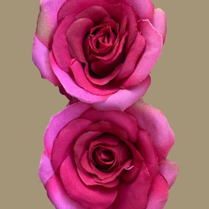 Peut inclure: Deux roses en tissu rose avec un centre rose fonc&eacute;. Les roses sont superpos&eacute;es.