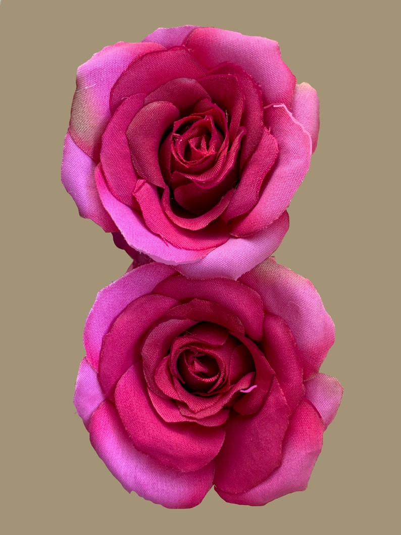 Peut inclure: Deux roses en tissu rose avec un centre rose fonc&eacute;. Les roses sont superpos&eacute;es.