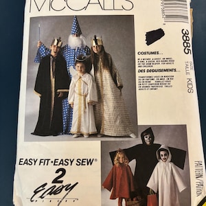 May include: McCall's costume pattern featuring a wizard, ghost, angel, king, queen, Red Riding Hood, and Grim Reaper designs. The pattern includes sizes for adults and children. The package has the text "Easy Fit Easy Sew".