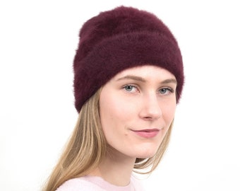 Elegant winter cap made of angora in "wine-red".The soft designer beanie keeps you warm on frosty winter days and makes for a cool look. Lil