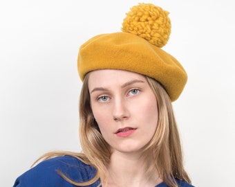 Light, soft woollen basque with a large pompon in bright golden yellow. Warming, elegant cap with French charm for cool autumn days. Babette