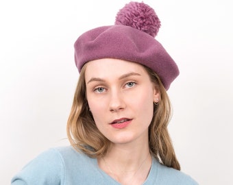 Béret en laine douce pour femme avec un gros pompon en "Mauve" doux. Chapeau chaud et élégant au charme français pour les fraîches journées d'automne. Babette