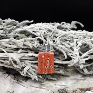 May include: A silver chain necklace with a square pendant. The pendant is made of orange glitter resin with silver wire accents.