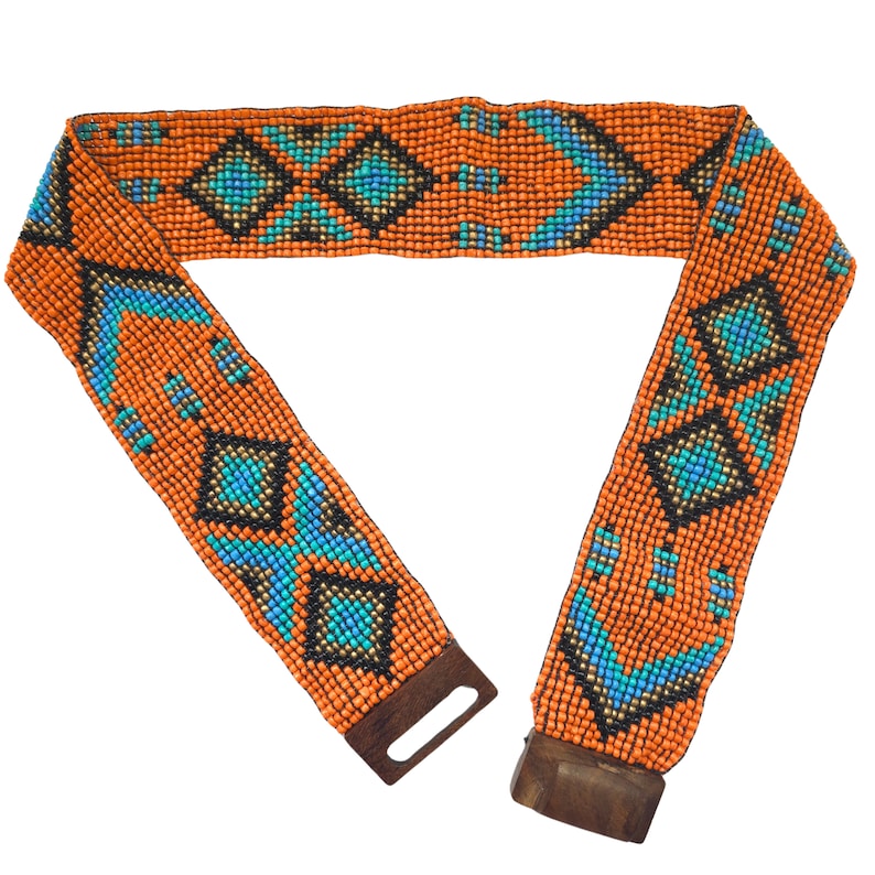 May include: A beaded belt with a geometric pattern in orange, blue, and black. The belt has a wooden buckle.