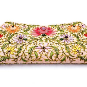 May include: A pink clutch purse with a floral design. The flowers are embroidered with colorful beads and sequins.