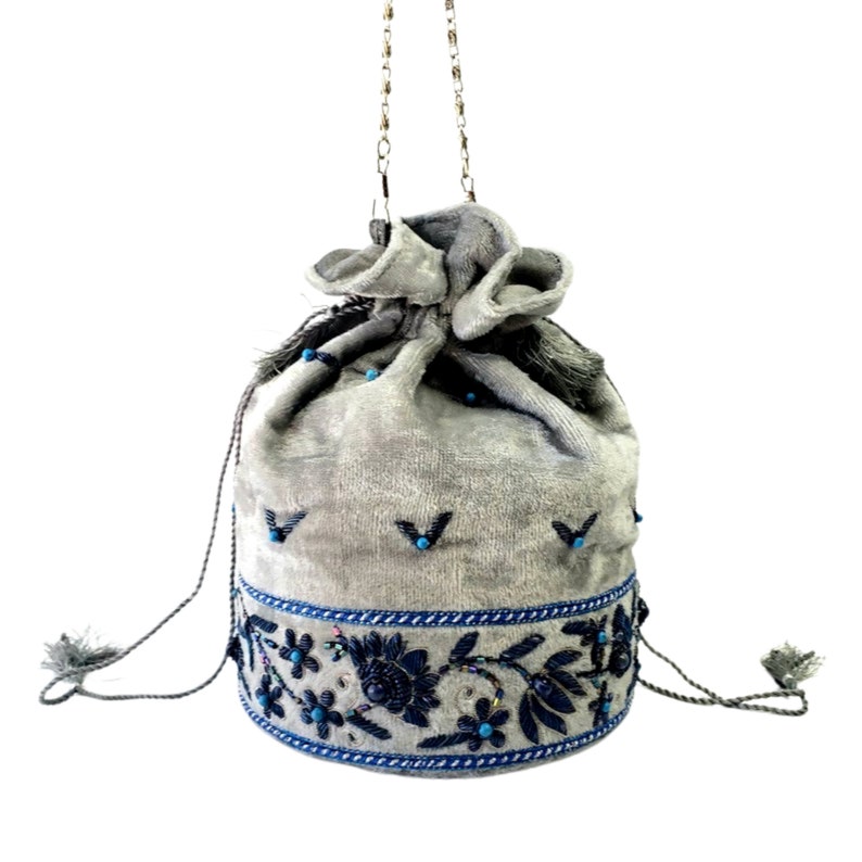 May include: A gray velvet drawstring bag with a chain strap and blue embroidered floral details.
