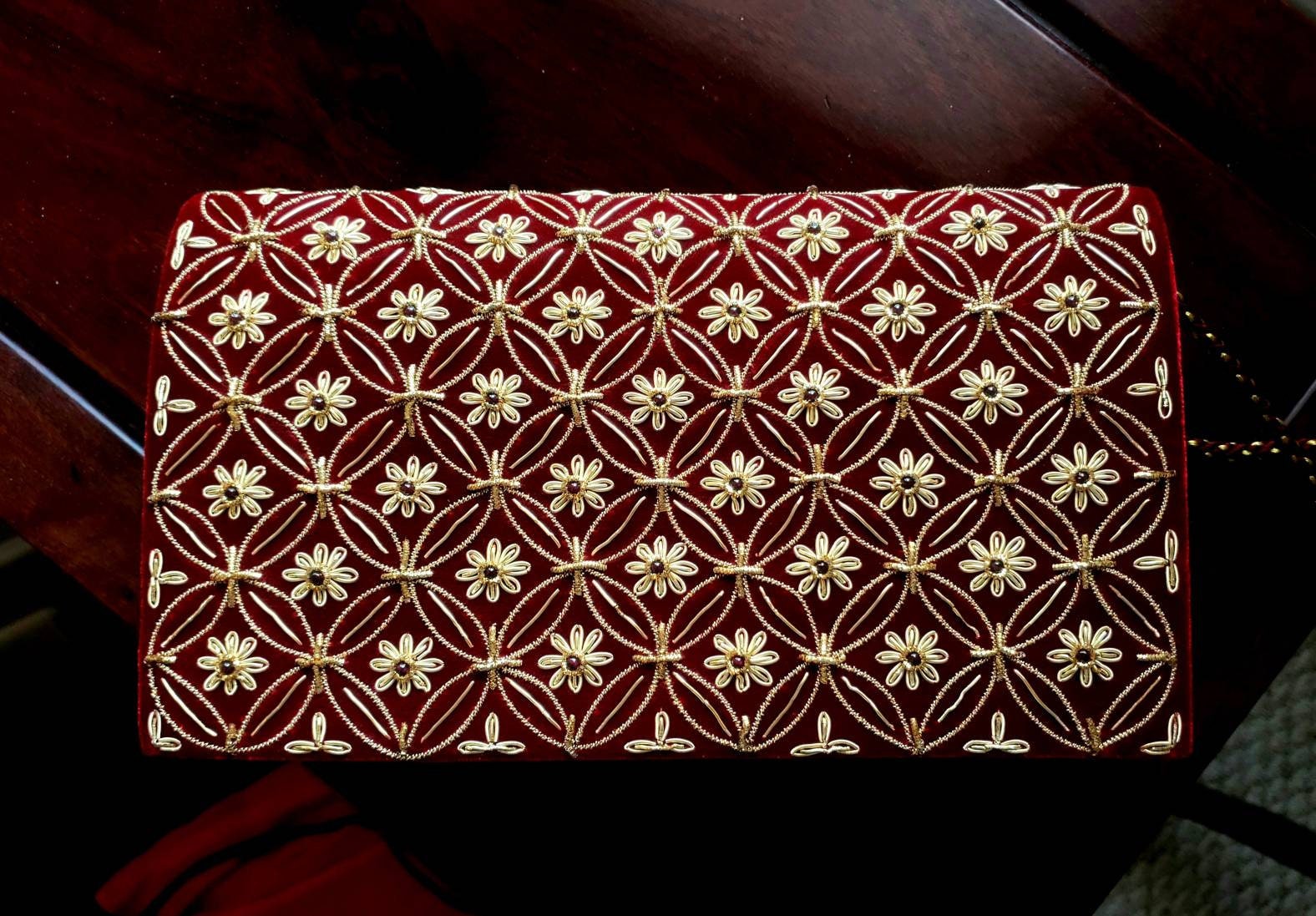 burgundy and gold clutch bag