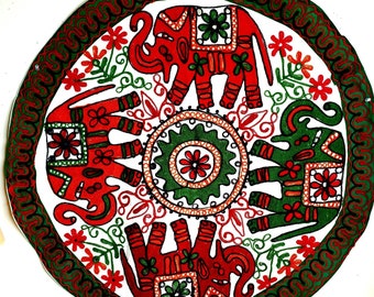 May include: Circular wall hanging with a white background and a green border. Four red and green elephants are embroidered in the center of the circle. The elephants are surrounded by a green and red floral design.