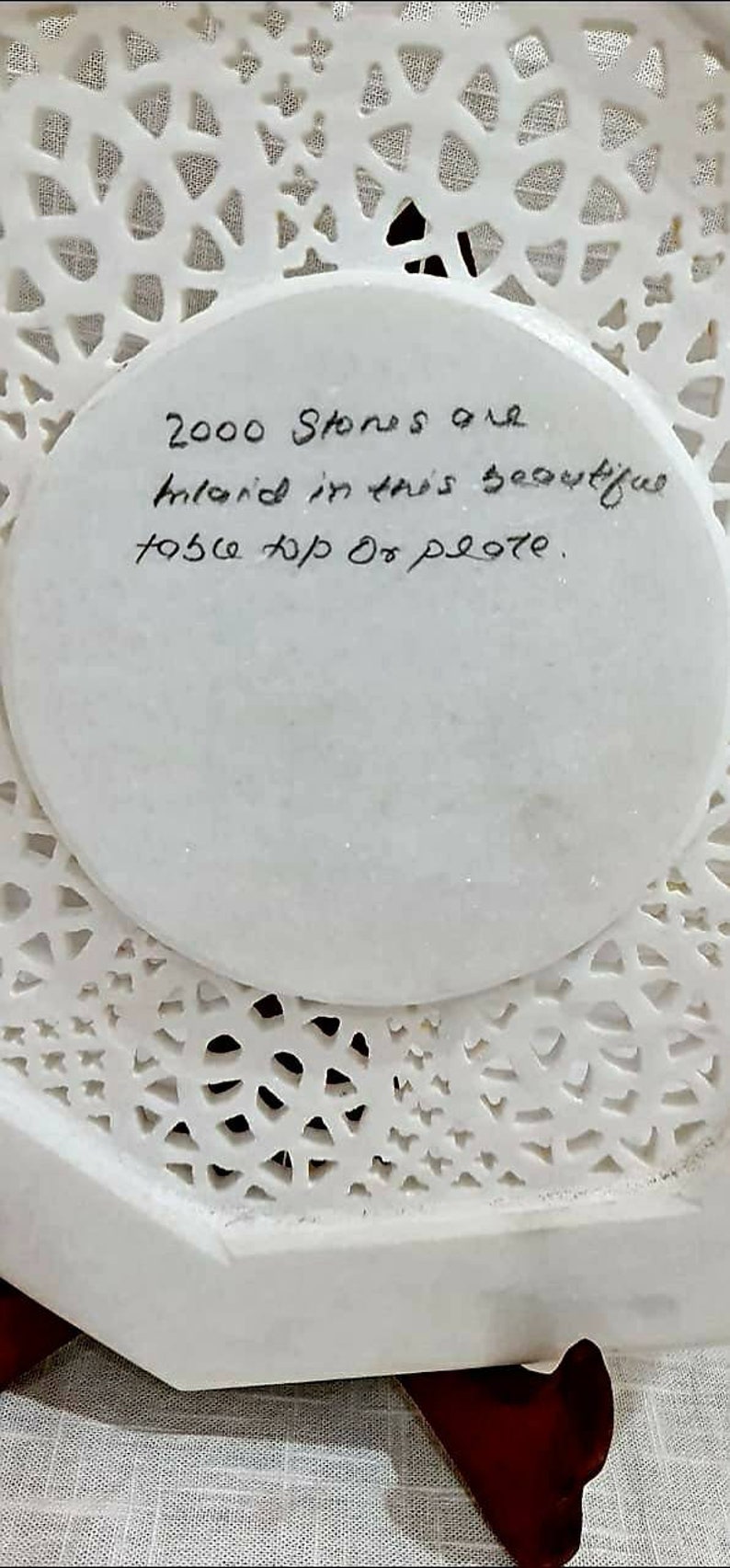 Puede incluir: Un plato de m&aacute;rmol blanco con intrincados recortes. El plato tiene una inscripci&oacute;n circular que dice "2000 Stones are inlaid in this beautiful top of plate."