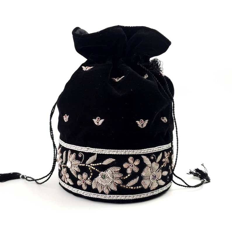 May include: Black velvet drawstring bag with silver and gold embroidery featuring floral designs and pink and green gemstones.
