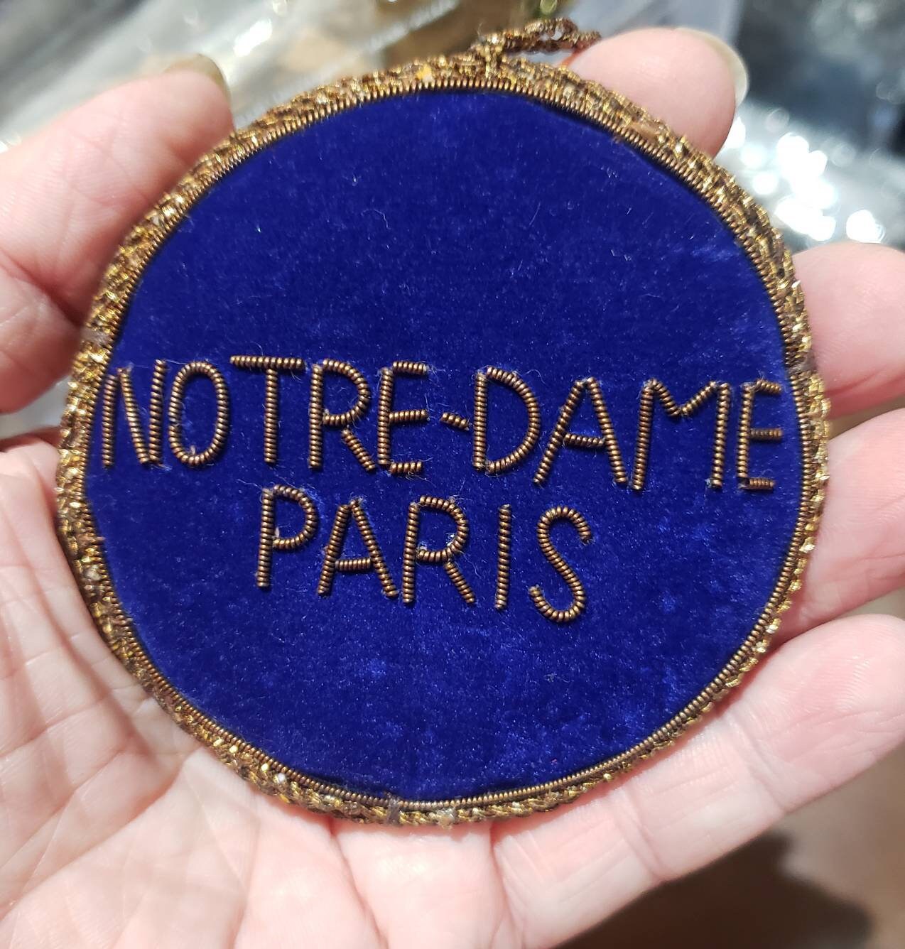 Embroidered back of Notre Dame Rosette Window Christmas Ornament to say
