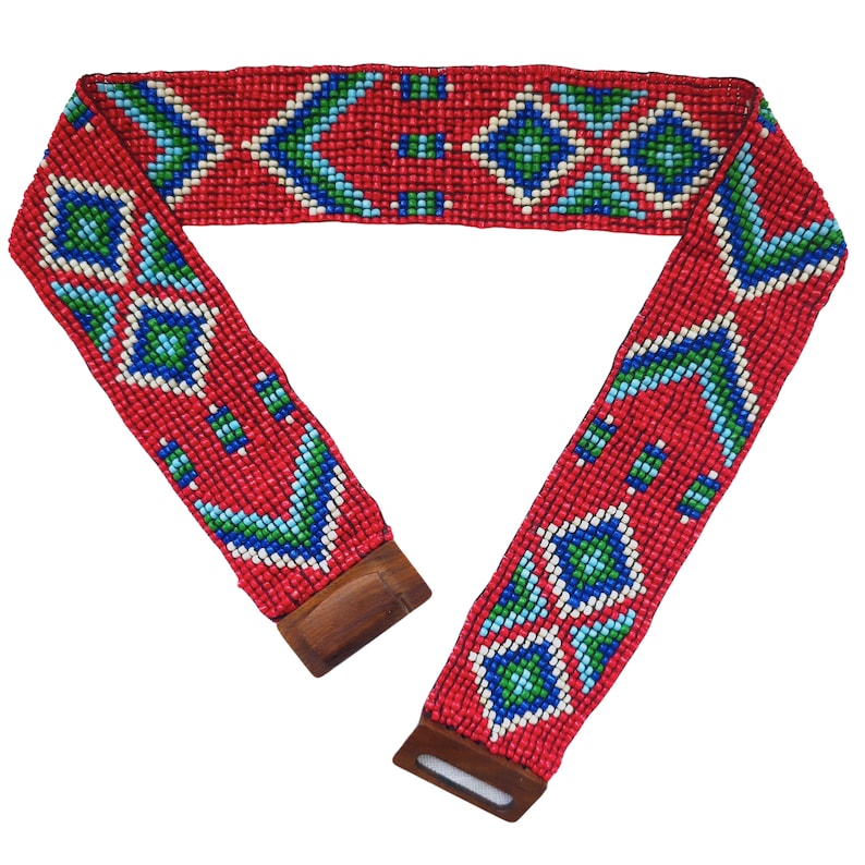 May include: A red beaded belt with a geometric pattern in blue, green, and white. The belt has wooden buckles on each end.