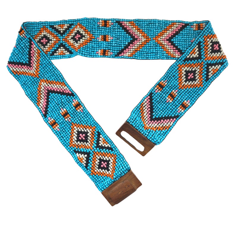 May include: A turquoise beaded belt with a geometric pattern in orange, pink, white, and black. The belt has a wooden buckle.