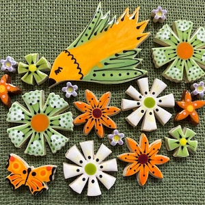May include: A collection of ceramic mosaic tiles featuring a yellow bird with green wings, various multi-petaled flowers in shades of green, white, and orange, small purple blossoms, and an orange butterfly with black markings and spots.