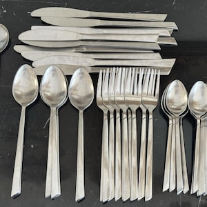 May include: A set of stainless steel cutlery, including spoons, forks, and knives. The spoons have rounded bowls and long, flat handles. The knives have a sleek design. The forks have four tines. Suitable for a formal dining occasion.