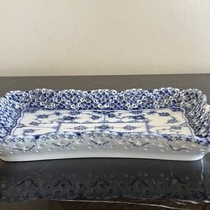May include: A white porcelain serving tray with a blue and white floral pattern and a lace-like border.