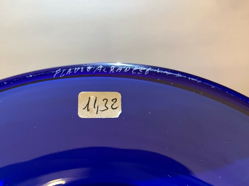 Puede incluir: Primer plano de un cuenco de vidrio azul cobalto con una pegatina blanca en la parte inferior que dice "1132".