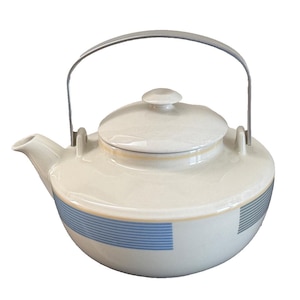 May include: Cream-colored ceramic teapot with a lid and a metal handle. The teapot features blue and gray horizontal stripes around the base and a yellow stripe near the top. The spout is on the left side.