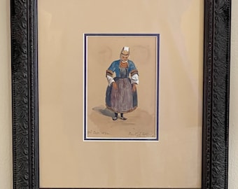 May include: A framed watercolor painting of a woman wearing a traditional costume. The woman is standing in a field and is holding a basket. The painting is in a black frame with a gold mat.