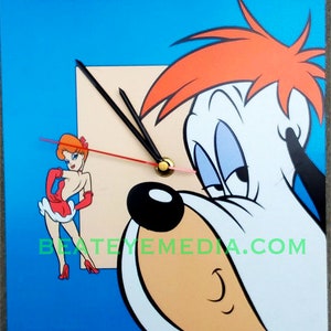 Può includere: Un orologio quadrato con un'immagine di un cartone animato di un cane con i capelli rossi e una donna con un vestito rosso. Il quadrante dell'orologio è bianco con lancette nere e un centro dorato. Il testo "BeatEyeMedia.com" è stampato sull'orologio.