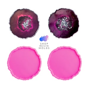 May include: Two finished resin coasters with a geode design in shades of purple and silver. Two pink silicone molds for making resin coasters with a geode design.