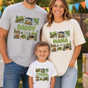 May include: A grey t-shirt with the text DADDY, a cream t-shirt with the text MAMA, and a white t-shirt with the text CORBIN. Each shirt features a graphic print of various reptiles, including an iguana, a turtle, and a lizard in a terrarium.