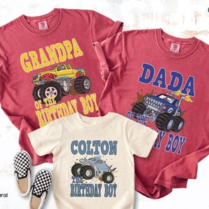 May include: Crimson and natural-colored t-shirts with monster truck graphics. One shirt says "Grandpa of the Birthday Boy," another says "Dada of the Birthday Boy," and the third says "Colton the Birthday Boy."