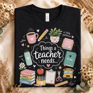 May include: A black t-shirt featuring a graphic with the text "Things a teacher needs..." surrounded by illustrations of a pink coffee mug, pencil, potted plant, sticky notes, water bottle, planner, books, apple, clipboard, scissors, bus, and ruler.