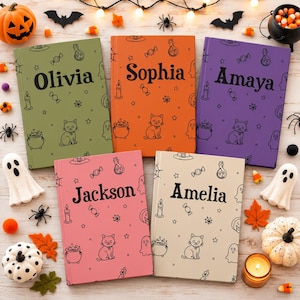 Puede incluir: Cinco cuadernos rectangulares en verde oliva, naranja, morado, rosa y crema. Cada portada presenta un patrón de líneas negras con gatos, fantasmas, calderos y dulces, con un nombre único impreso en negro: Olivia, Sophia, Amaya, Jackson y Amelia.