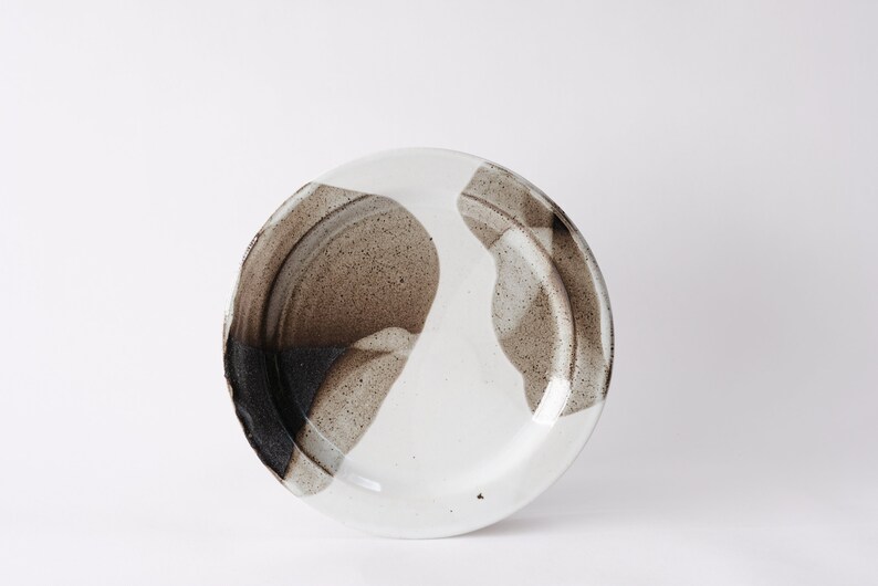 handmade stoneware dinner plate, two tone warm black and white glazes overlapping creating a gradient of warm earthy grays in between.