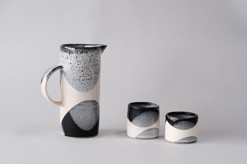 beautiful handmade ceramic water jug or pitcher. Decorated with black and white overlapping glazes which create a modern geometric pattern.