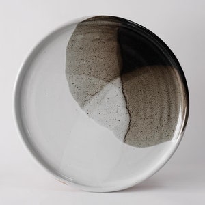 handmade stoneware dinner plate, two tone warm black and white glazes overlapping creating a gradient of warm earthy grays in between.