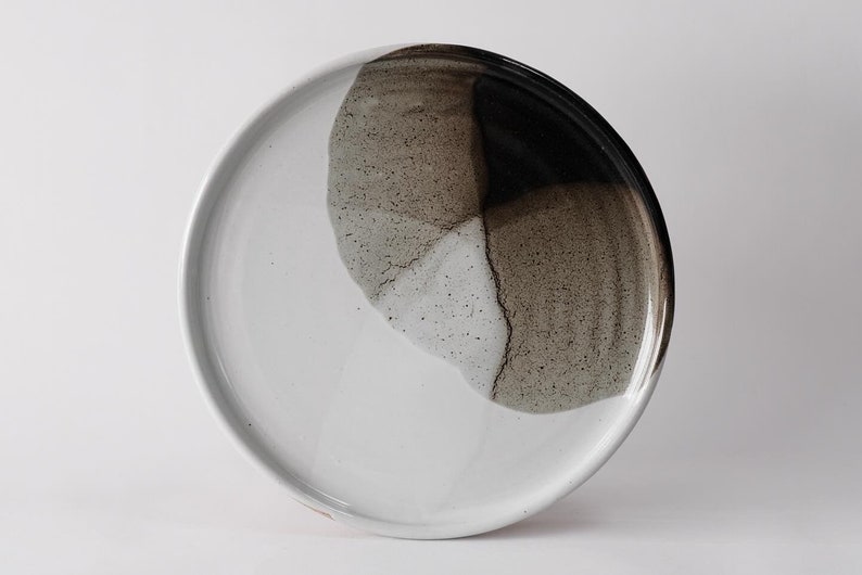 handmade stoneware dinner plate, two tone warm black and white glazes overlapping creating a gradient of warm earthy grays in between.